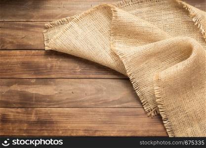 burlap hessian sacking on wooden background table, top view