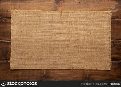 Burlap hessian sacking texture on wooden background surface