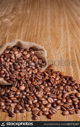 burlap sack of coffee beans on old wooden table