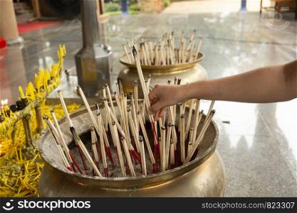 Burning aromatic incense sticks in temple for praying Buddha or Hindu gods to show respect