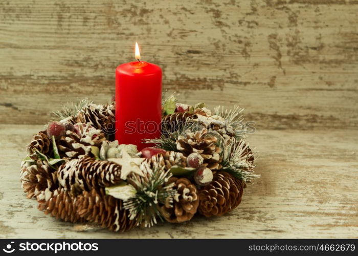 Burning candle in a Christmas setting with seasonal decorations.