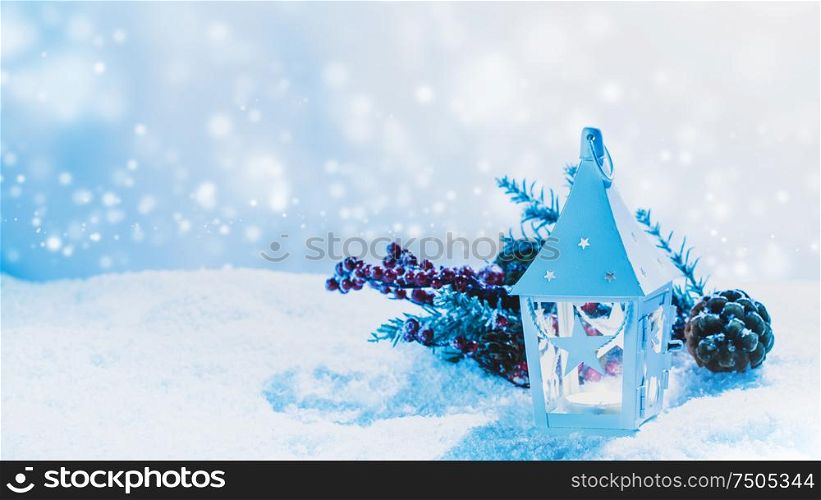 Burning candle in lantern and christmas decoration on snow. Lantern and christmas decoration