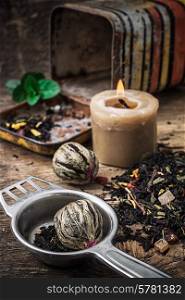 burning candle on the background of scattered tea with lime and mint in rustic style.Selective focus. tea brew with lime and mint on wooden background