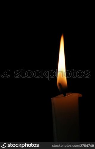 Burning candle on the isolated black background