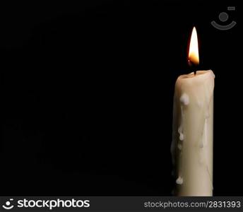 Burning candle over black. Is not isolated, just shot on black