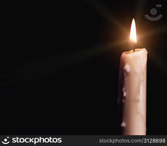 Burning candle over black. Is not isolated, just shot on black