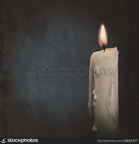 Burning candle over dark backgrounds. Abstract grungy still life
