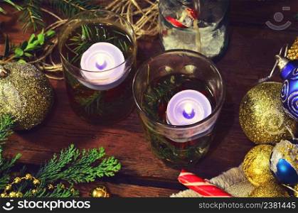 Burning candle with christmas baubles decoration, fir tree. Christmas candles lights.. Burning candle and Christmas tree decoration.