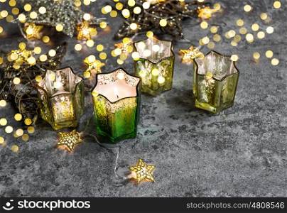 Burning candles and golden stars. Christmas lights decoration