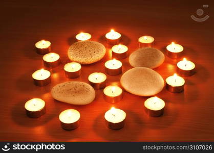 Burning candles and pebbles for aromatherapy session