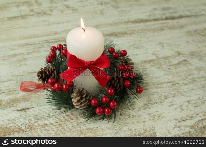 Burning candles in a Christmas setting with seasonal decorations.