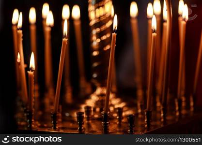 burning candles in church on dark background.. burning candles in church on dark background