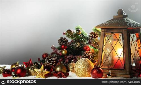 Burning candles , lantern and christmas decoration of baubles, fir branches and cones. Lantern and christmas decoration
