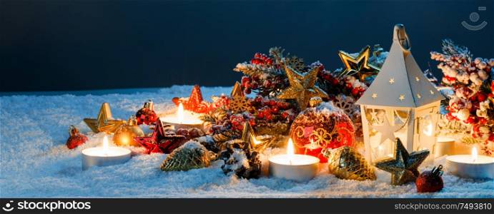 Burning candles , lantern and christmas decoration on snow. Lantern and christmas decoration