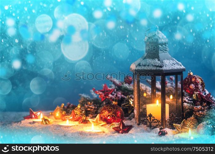 Burning candles , lantern and christmas decoration on snowfall background. Lantern and christmas decoration