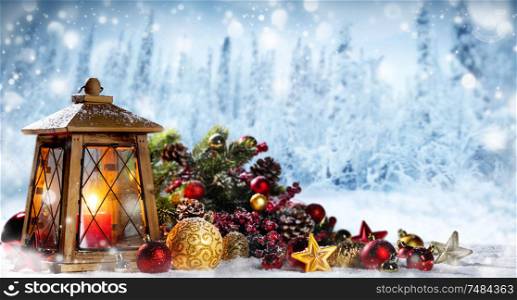 Burning candles , lantern and christmas decoration on winter forest bokeh background. Lantern and christmas decoration
