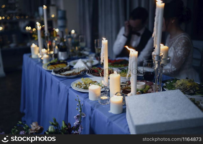 Burning candles on a festive table. A festive table with candles