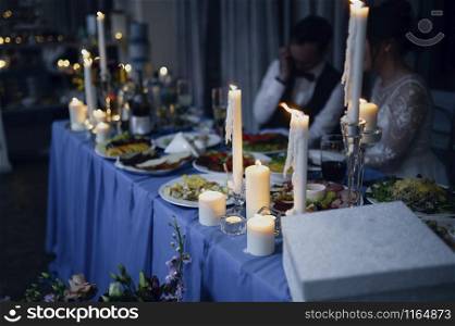 Burning candles on a festive table. A festive table with candles