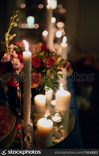 Burning candles on a festive table. A festive table with candles. A wedding table with burning candles. Romantic dinner. Burning candles on a festive table. A festive table with candles