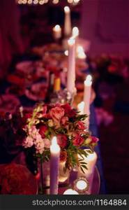 Burning candles on a festive table. A festive table with candles. A wedding table with burning candles. Romantic dinner. Burning candles on a festive table. A festive table with candles