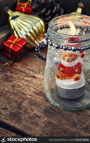 Burning Christmas candle. Burning Christmas candle in the shape of a bear cub in glass stylish candle holder