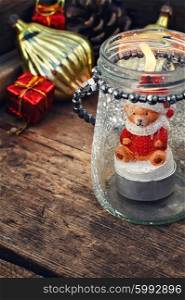 Burning Christmas candle. Burning Christmas candle in the shape of a bear cub in glass stylish candle holder