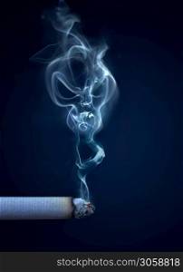 burning cigarette with smoke in the shape of a skull - conceptual image