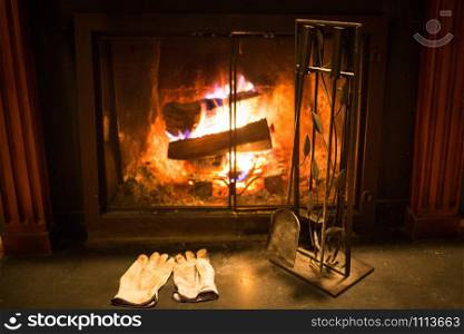 Burning cozy fireplace hearth with tools and gloves empty. Burning cozy fireplace hearth with tools and gloves