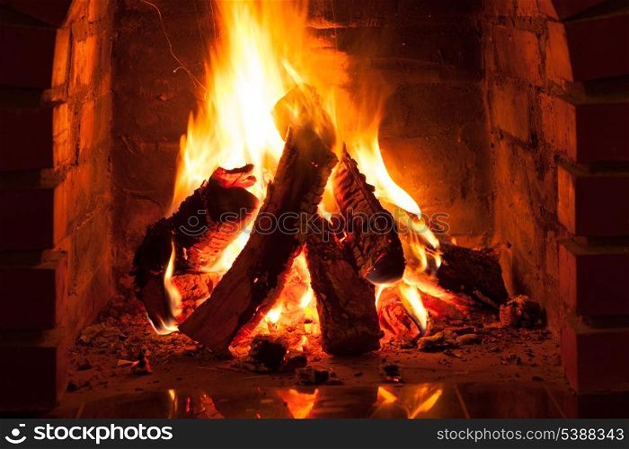 Burning fire in the brick fireplace, close up