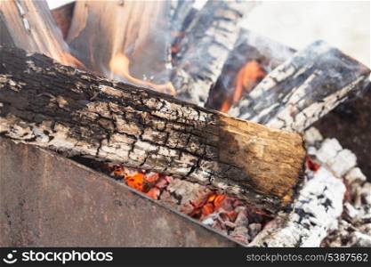 Burning firewood in grill for barbecue close up