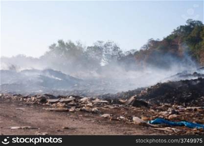 Burning garbage heap of smoke from a burning pile of garbage that&rsquo;s being air pollution.