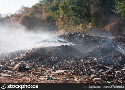 Burning garbage heap of smoke from a burning pile of garbage that&rsquo;s being air pollution.