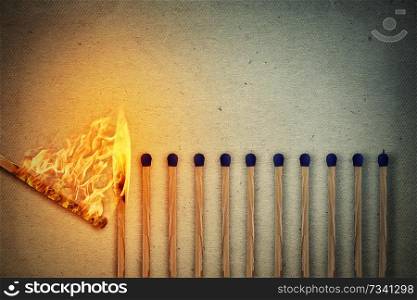 Burning match setting fire to its whole neighbors, a metaphor for ideas and inspiration. Leadership concept