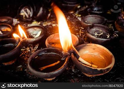 Burning oil lamps at temple. Traditional offering in buddhist and hindu temple