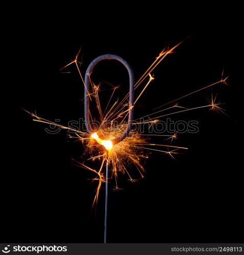 Burning sparkler in shape of number zero, digit 0, isolated on black background.