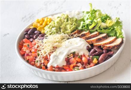 Burrito bowl with chicken, salsa, corn, rice, kidney beans and guacamole
