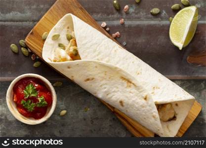 burrito cutting board near tomato sauce sliced lime cardamom seeds