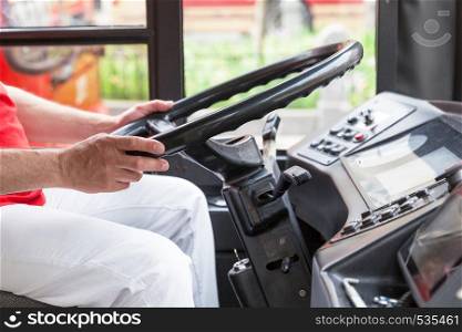 Bus driver at work, holding steering wheel