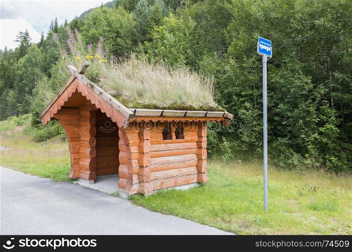 Bus stop on the side of the road on the country side in norway. The Majestic mountains landscape, fjord in Norway with wooden bus stop. traditional wooden bus stop with grass covered roof,. traditional bus stop in Norway