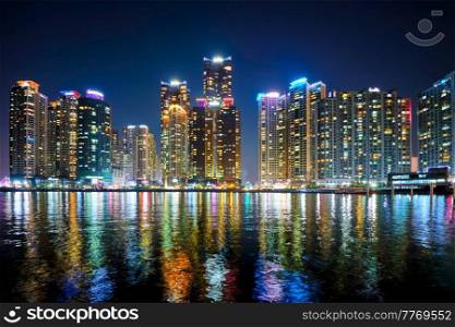 Busan Marina city skyscrapers illluminated in night with reflection in water, South Korea. Busan Marina city skyscrapers illluminated in night