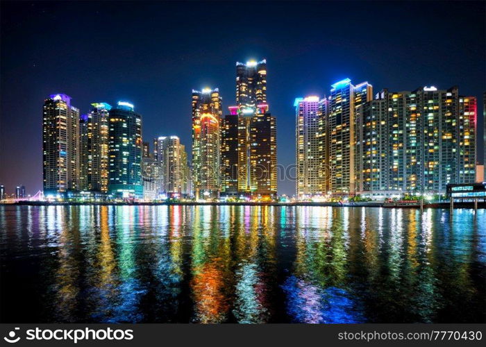 Busan Marina city skyscrapers illluminated in night with reflection in water, South Korea. Busan Marina city skyscrapers illluminated in night