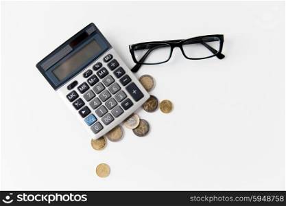 busines, finance, money and bookkeeping concept - calculator, eyeglasses and euro coins on office table