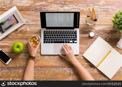business, accounting and freelance concept - hands of woman with receipt on laptop computer working at office. hands with receipt on laptop screen at office