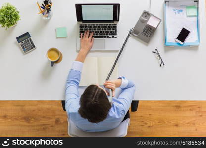 business, accounting and people concept - businesswoman with laptop computer calling on phone at office table. businesswoman calling on phone at office table