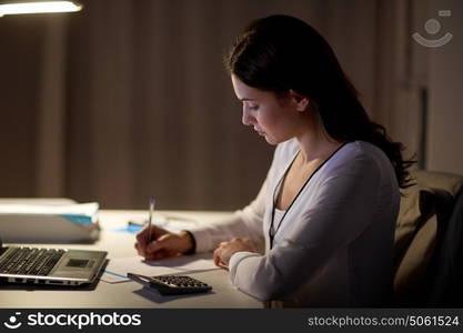 business, accounting, overwork, deadline and people concept - woman with tax form and calculator working at night office. woman with calculator and papers at night office