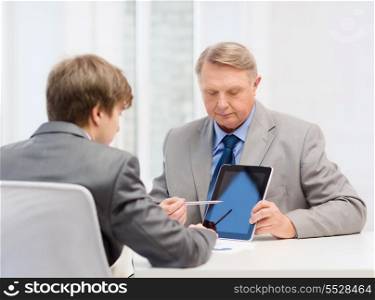 business, advertisement, technology and office concept - older man and young man with tablet pc computer in office