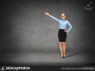 business, advertising and office concept - smiling businesswoman in eyeglasses pointing her hand