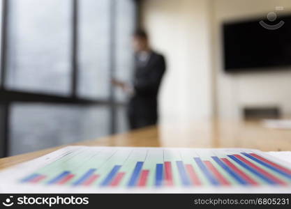 business analysis chart report with background of businessman in suit standing beside office window