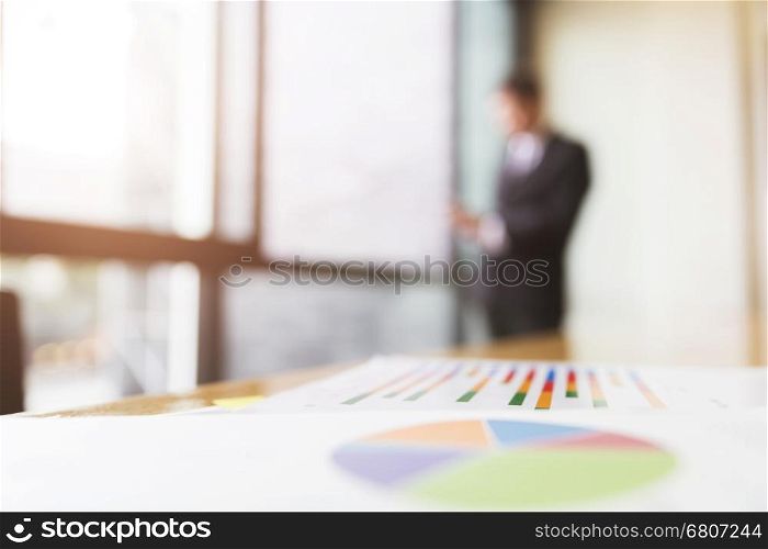 business analysis chart report with background of businessman in suit standing beside office window
