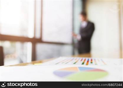 business analysis chart report with background of businessman in suit standing beside office window